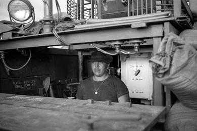 Boat skipper BMC (Chief Boatswain's Mate/Chief Petty Officer) Walter R. Cullen controls the boat while underway.
