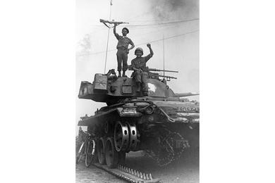 Vietnam soliders celebrate atop a broken tank.
