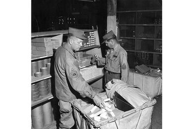 SERVING THEMSELVES are SFC Richard J. Kingston (left) and Sgt. Lewis F. Jones, both "shopping" for their units at the new Quartermaster Self-Service Supply Center that opened at Yongdong-po recently.