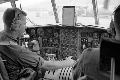 Two unidentified pilots inside the cockpit of an aircraft, somewhere in South Vietnam. Photographer did not provide any caption information for this photo.