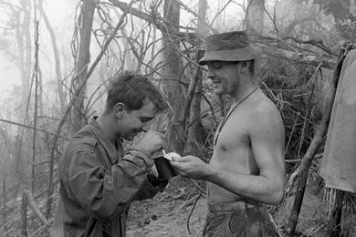 Two Marines share a can of C-rations for breakfast