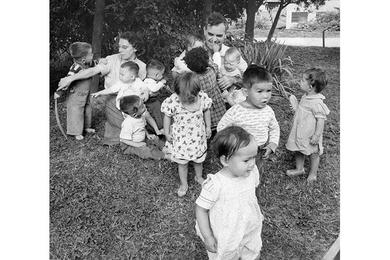 Harry S. Holt, farmer and sawmill operator, has his hands full trying to line up 12 Korean orphans for a Stars and Stripes portrait in Seoul.