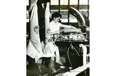 Shige Senanha, an employee at the U.S. Army Quartermaster Group Laundry and Dry Cleaning branch at Machinato, Okinawa, operates both the sleeve iron (foreground) and iron press. 
