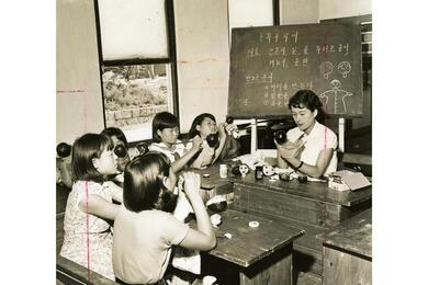 Girls paint puppets at an orphanage