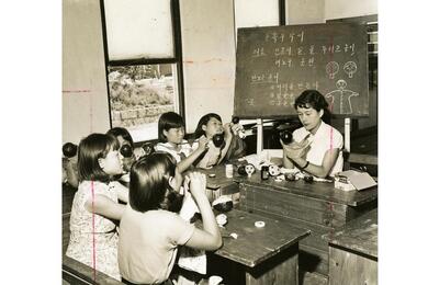 Children paint puppets in a classroom