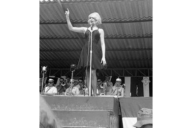 Miss Joey Hetherton sings and dances for the crowd of soldiers gathered at Di An for the Bob Hope Show.