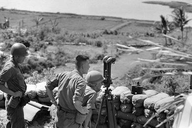 Two soldiers of the 28th RCT watch for Vietcong through telescope.