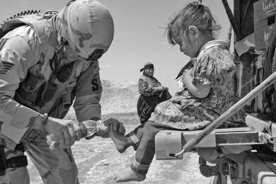 From the Stars and Stripes archives: Tech. Sgt. Jeffrey Fort, 33, of Florissant, Mo., an Air Force patrol leader, treats a local child for cuts on her feet during a recent patrol outside Ali Base in Iraq, April 2006.