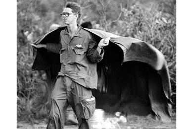 A soldier from 2nd Battalion, 27th Infantry, 25th Infantry Division stands in the rotor wash of a Chinook helicopter, hoping to dry out some of his jungle gear, at a new landing zone in the Iron Triangle northwest of Cu Chi.
