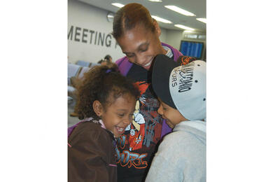 A mother hugs her children.