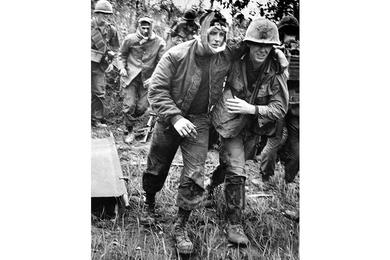 Injured gunship crewmen are helped to a Medevac copter during a three-day operation by B Company, 2nd Battalion, 12th Cavalry in the Que Son Valley, 35 miles from Da Nang.