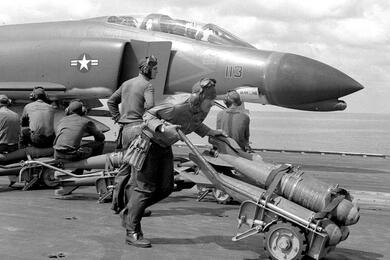 A sailor moves bombs.