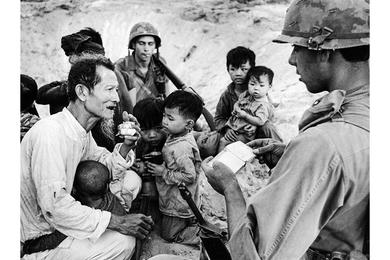 Gesturing toward his beard, a Vietnamese man tries to convince an infantryman who's checking his identity papers that he's too old to be a Viet Cong soldier.
