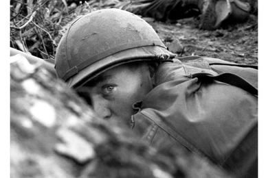 American soldiers take cover from enemy fire during a three-day operation by B Company, 2nd Battalion, 12th Cavalry in the Que Son Valley, 35 miles from Da Nang.