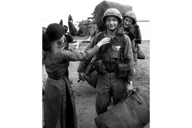 A soldier is given a flower by a Vietnamese girl as the 196th Light Infantry Brigade comes ashore near the end of a long journey from Fort Devens, Mass. in August, 1966.