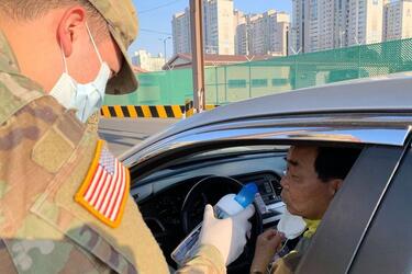 A driver takes a smell test as part of coronavirus screening measures at Camp Henry, South Korea, Friday, April 3, 2020.