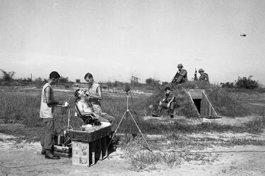 Capt. Earle Yeamans examines an infantryman’s teeth as his fellow soldiers look on.