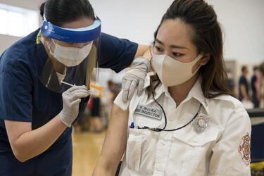 Fire inspector Kaede Miura receives her first dose of the Moderna COVID-19 vaccine at Yokosuka Naval Base, Japan, Friday, June 18, 2021.