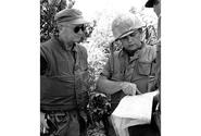 Col. Oscar Peatross, left, commander of the 7th Marine Regiment and head of Task Force Delta, is briefed by Lt. Col. Leon Utter,commander of the 2nd Battalion, 7th Marine regiment, during Operation Utah.