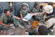 In a 2003 photo, Command Sgt. Maj. John Sparks delivers copies of Stars and Stripes to U.S. Marines from Weapons Platoon, 3-2 India Company.