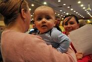 Ronin Barber, six months, waits his turn in a pre-processing line Saturday at Misawa Air Base, Japan, for family members wishing to leave Japan under a 'voluntary departure' program following a devastating earthquake and tsunamis that hit Japan on March 11.