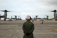 A Marine waits to guide MV-22 Ospreys with Marine Medium Tiltrotor Squadron 265, 31st Marine Expeditionary Unit, during their takeoff from Marine Corps Air Station Futenma, Okinawa.