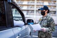 A sailor practices screening drivers for coronavirus symptoms at Yokosuka Naval Base, Japan, March 18, 2020.