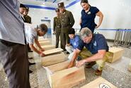Forensic anthropologists with the Defense POW/MIA Accounting Agency review the contents of cases containing the possible remains of service members lost in the Korean War during a unilateral transfer in Wonsan, North Korea, in July 2018.