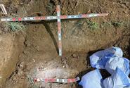 An unexploded bomb is seen being uncovered in the dirt.